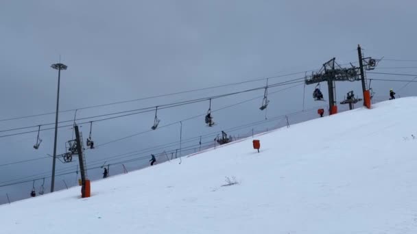 La pista de esquí en la estación de Igora, esquiadores y snowboarders se deslizan por la ladera nevada de invierno de la montaña. Teleférico, telesilla. Rusia, San Petersburgo, 2 de enero de 2022 — Vídeos de Stock