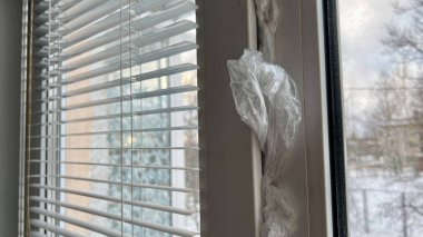 İki bardaktan yapılmış çift camlı pencereler çerçeveler ve izolasyonlar arasında selofan torbalarla yalıtılır. Pencerede bir hava akımı, havanın içeri girmesine izin verir. Kışın plastik pencerelerin yalıtımı.