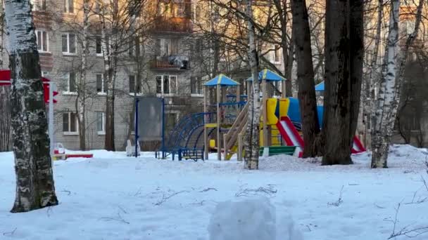 Un parque infantil vacío después de una nevada y ventisca, una vista del parque infantil bajo la nieve — Vídeos de Stock