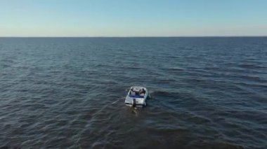 Yüksek hızlı beyaz zevk teknesinin Finlandiya Körfezi 'nin sularında yüzerken çekilmiş fotoğrafları. Denizdeki tekneden gelen büyük dalgalar. Motorlu tekneden köpük izi var.
