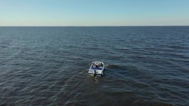 Letecké fotografie vysokorychlostního bílého rekreačního člunu plujícího ve vodách Finského zálivu. Velké vlny z lodi v moři. Z motorového člunu vede pěnová stopa. — Stock video