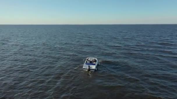 Aerial photographs of a high-speed white pleasure boat sailing in the waters of the Gulf of Finland.Big waves from the boat in the sea. There is a foam trail from the motor boat — Stock Video