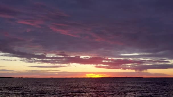 Ilmakuva dramaattisesta auringonlaskusta Suomenlahden yllä, auringonlaskun heijastus Itämeren aalloissa. Violetti tai violetti pilvet. Aurinko vajosi horisontin alapuolelle — kuvapankkivideo