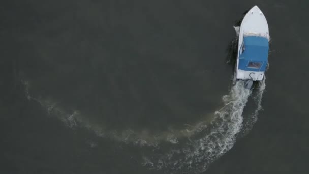 Letecký pohled na motorový člun s modrou střechou pohybující se v kruhu a vytvářející krásné tvary v moři. Koncept rekreace a cestování — Stock video