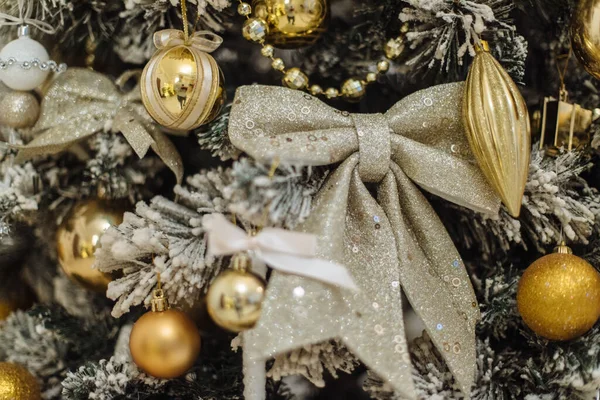 Gros plan du fond de l'arbre de Noël avec des jouets. Décoration avec un arc de Noël, branches de sapin. Décor de Noël. Le concept de vacances d'hiver. Bonne année. — Photo