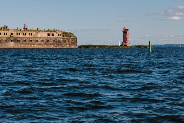 Blick vom Wasser auf die Festung Kronshlot, den unteren Leuchtturm auf der Insel, die Gewässer des Finnischen Meerbusens, die Fahrrinne von Kronstadt. — Stockfoto