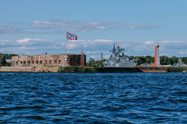 Vista desde el agua del puerto y el estacionamiento de buques de guerra y submarinos, la costa de Kronstadt, las aguas del Golfo de Finlandia, el mar azul y las olas. Rusia, Kronstadt, 31.07.2021 Fotos De Stock