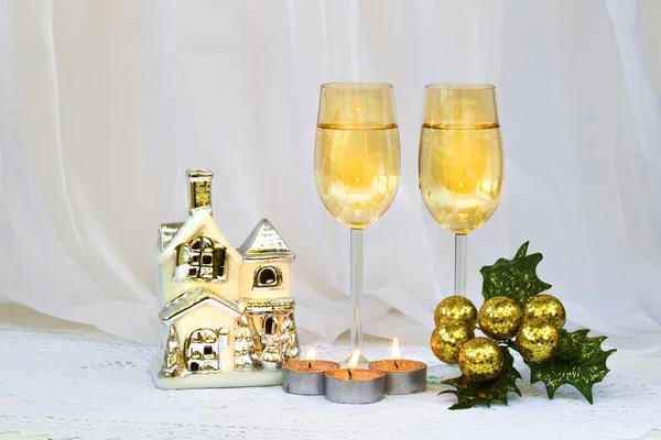 Christmas composition with two wine glasses, a small house-holder and candles. — Stock Photo, Image