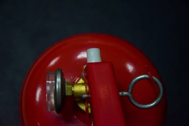 Yangın söndürücünün üst görüntüsü. Siyah bir arka planda, yakıtlı bir yangın söndürücünün yakın planında, içine bir kontrol ve defter yerleştirilmiş. Yangını söndürmek için özel bir cihaz..