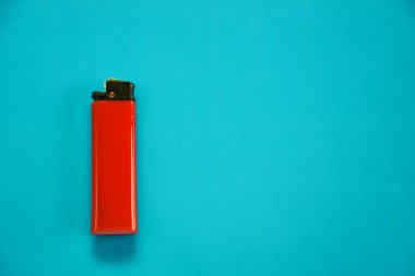 Mavi arka planda kırmızı renkli gaz lambası. Tasarımın için yakın çekim yüzeyi. Boş gaz plastik çakmak modeli. Yakın çekim, üst görüntü.