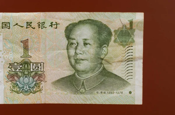 one yuan paper chinese money on a red background