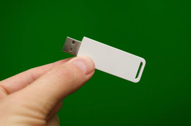 USB flaş bellek plastiği elinde yeşil bir arka planda