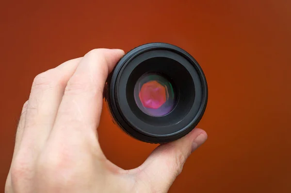 Mão Masculina Segurando Uma Lente Câmera Fundo Laranja — Fotografia de Stock