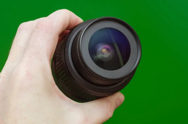 Obiettivo Della Fotocamera Una Mano Maschile Uno Sfondo Verde — Foto Stock