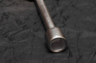 Siyah arka planda araba tekerleklerini tamir etmek için metal anahtar.