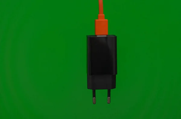Универсальное Черное Зарядное Устройство Гаджетов Оранжевым Кабелем Зеленом Фоне — стоковое фото