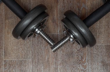 Ahşap zemindeki bir odada metal halterler. Sağlıklı yaşam tarzı kavramı.