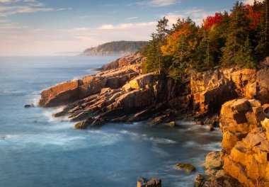 Acadia Ulusal Parkı, ME-USA - 13 Ekim 2021: Maine 'deki Acadia Ulusal Parkı' ndaki Newport Koyu 'nda gün doğumunun yatay görüntüsü. Sahil şeridi ve ormanın altın saat manzarası.