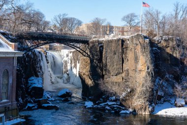 Paterson, NJ - ABD - 30 Ocak 2022 Kış boyunca Paterson Great Falls Ulusal Tarih Parkı 'nda kısmen donmuş düşüşün yatay görüntüsü.