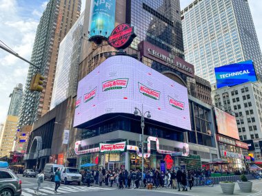 New York, New York - ABD - 26 Mart 2022: Times Meydanı 'nın yeni Krispy Kreme bayrak gemisinin yatay görüntüsü benzersiz bir donut tiyatrosu, tatlı ikramların nasıl yapıldığını gösteriyor.