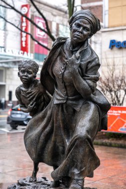White Plains, New York - ABD - 3 Nisan 2022 Wesley Wofford 'un 9 fit uzunluğundaki bronz heykeli Harriet Tubman' ın Özgürlük Yolculuğu. Tubman 'ı resmetmek, genç köle bir kızı özgürlüğe götürüyor..
