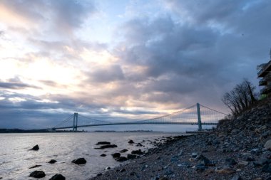 Staten Island, New York - ABD - 10 Nisan 2022: Panoramik gündoğumu manzaralı ikonik Verrazzano-Narrows Köprüsü, Narrows nehri boyunca uzanan asma köprü. Staten Island 'da görüldü..