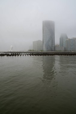 Jersey City, NJ - ABD - 20 Mayıs 2022 Jersey City 'nin Newport bölümünün sisli sabah manzarası. Su 'nun Ruhu, Hudson Nehri Rıhtım Yolu boyunca uzanan bir heykel. Jaume Plensa tarafından yaratıldı.