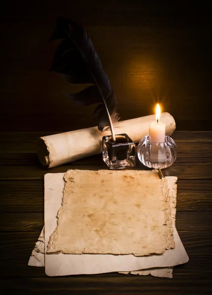 Pluma, papel viejo y vela sobre fondo de madera — Foto de Stock