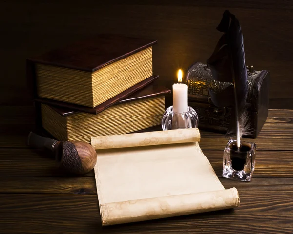 Pírko, starý papír a svíčku na dřevěné pozadí — Stock fotografie