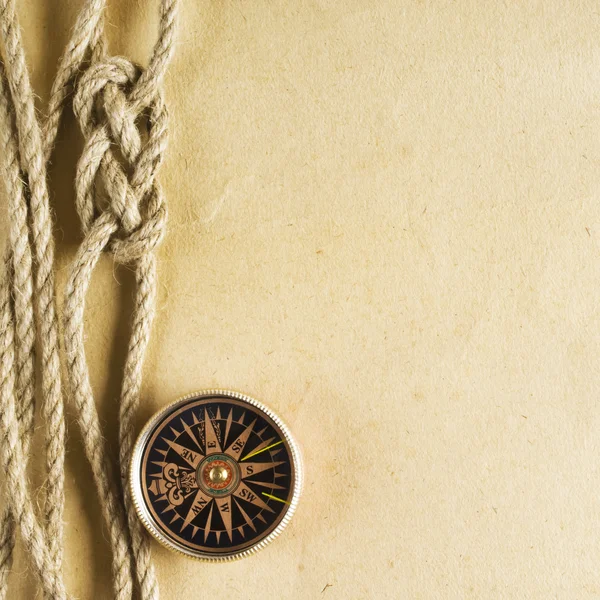 绳子和旧纸张背景上的指南针 — 图库照片