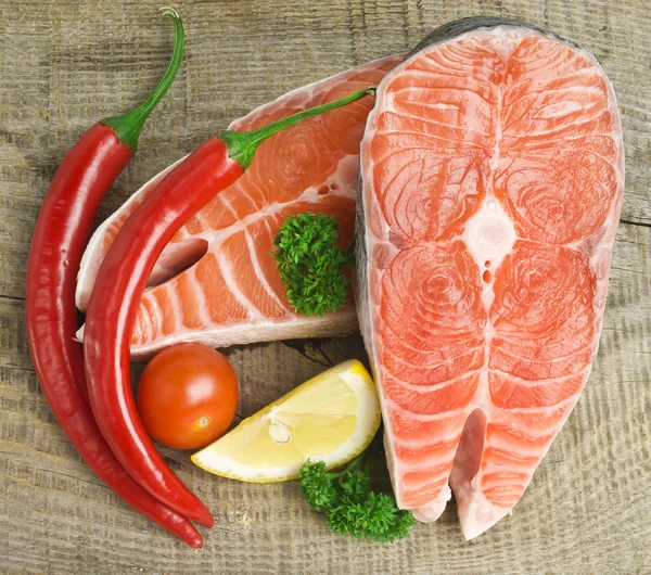 Сырой лосось, овощи и специи на старом деревянном столе — стоковое фото