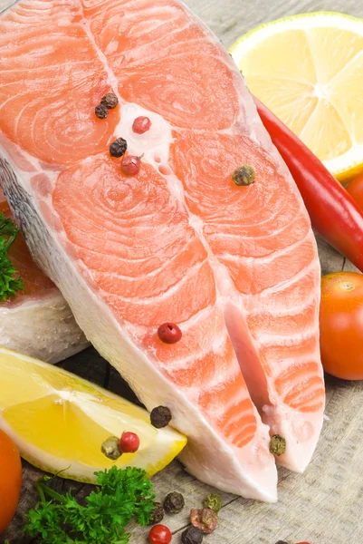 Raw salmon, vegetables and spices on an old wooden table — Stock Photo, Image