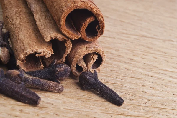 Palos de especias de canela en el tablero de madera de cerca —  Fotos de Stock