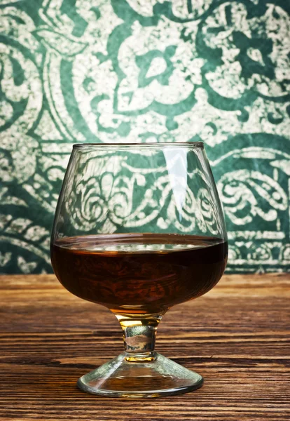Cognac glass on vintage background — Stock Photo, Image