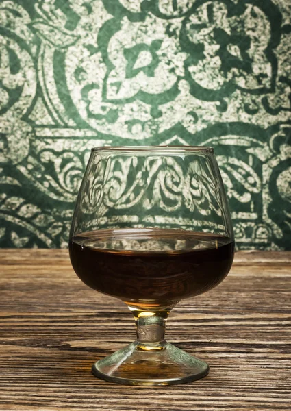 Cognac glass on vintage background — Stock Photo, Image