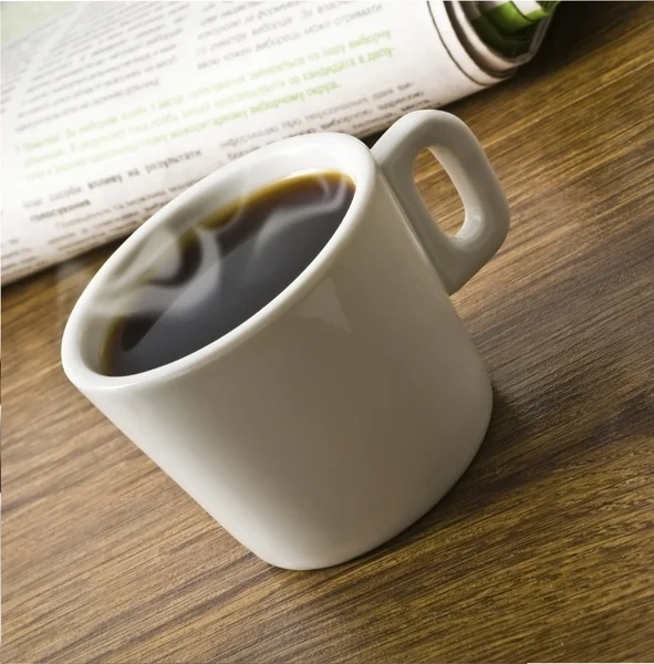 Cup of coffee and stack of newspapers — Stock Photo, Image