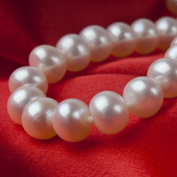 豪華なサテンの背景に真珠のネックレス — ストック写真