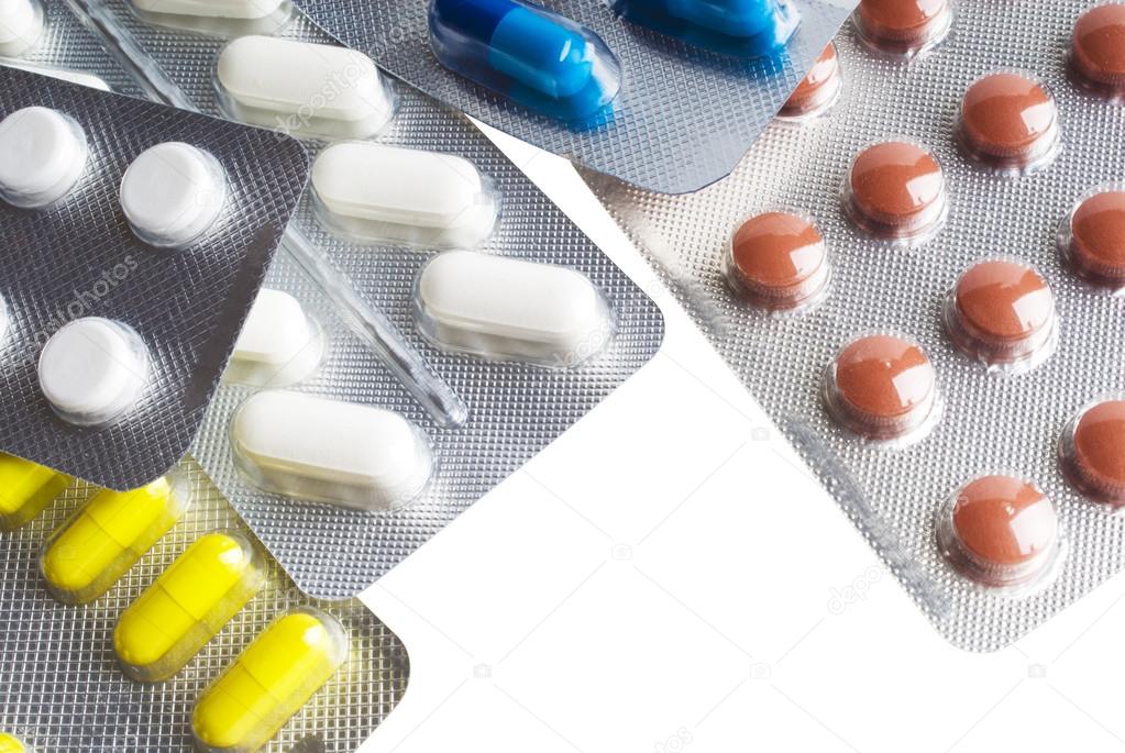 Capsules and pills packed in blisters close-up background