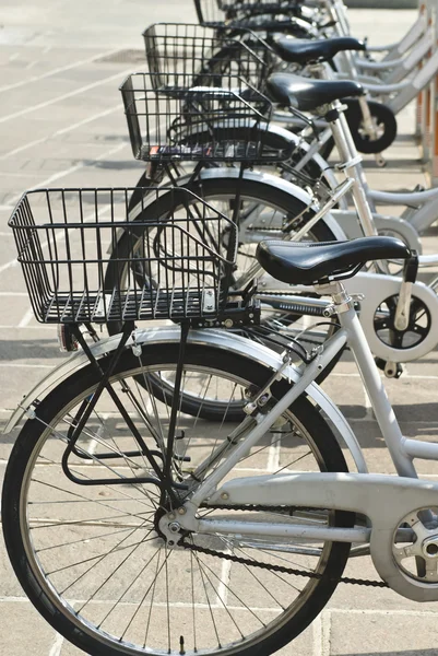 Noleggio biciclette in città parcheggiate in fila — Foto Stock