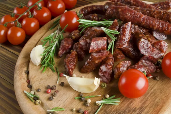 Smoked sausage with rosemary and peppercorns tomatoes and garlic — Stock Photo, Image