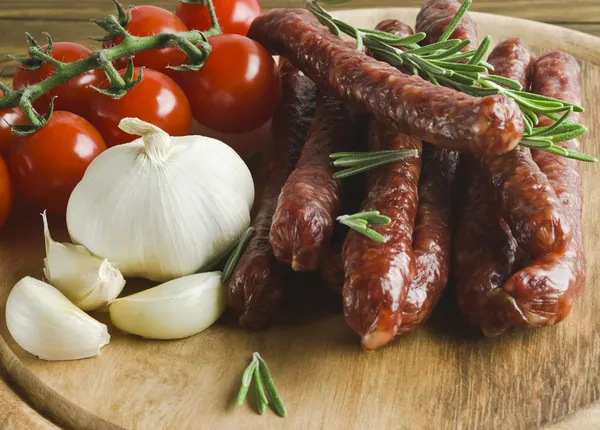 Smoked sausage with rosemary and peppercorns tomatoes and garlic — Stock Photo, Image