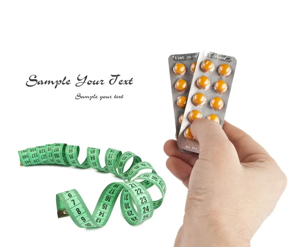 Measure tape with pills on hand — Stock Photo, Image