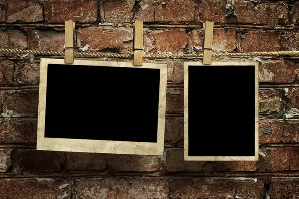 Imágenes en una cuerda con pinzas de ropa, con recorte de camino para las imágenes, frente a una pared de ladrillo — Foto de Stock