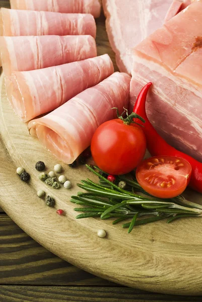 Fette di prosciutto fresco con lattuce e pomodoro ciliegia sul tagliere di legno — Foto Stock