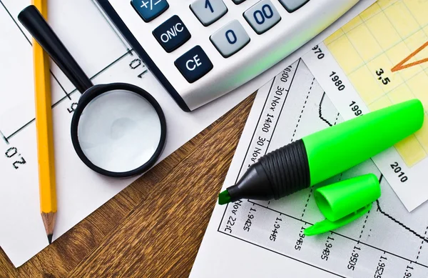 Calculadora sobre tabla de papel con diagrama — Foto de Stock