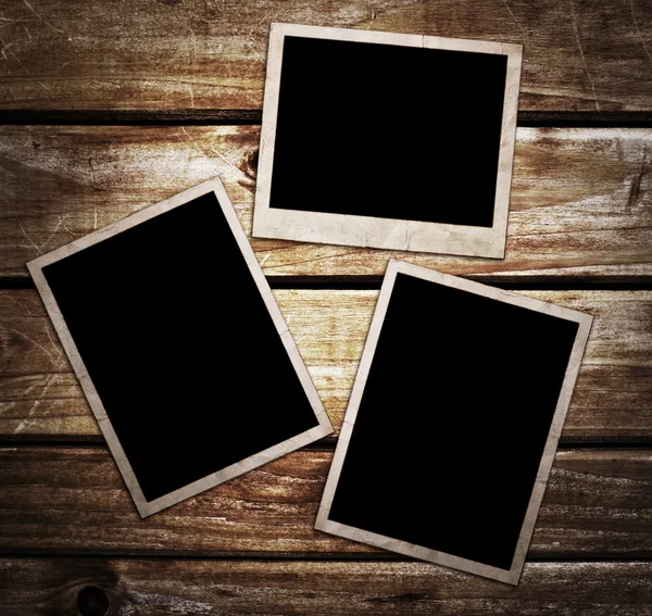 Aged photo frames on wood background — Stock Photo, Image