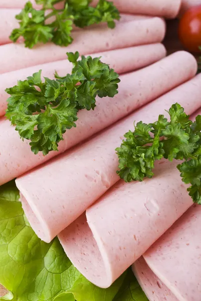 Fette di prosciutto fresco con lattuce e pomodoro ciliegia sul tagliere di legno — Foto Stock