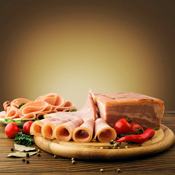 Fette di prosciutto fresco con lattuce e pomodoro ciliegia sul tagliere di legno — Foto Stock