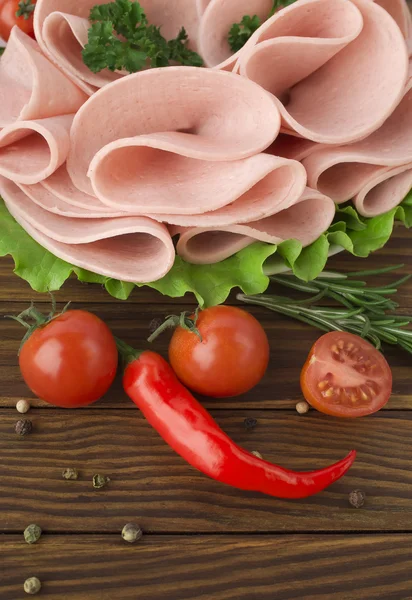 Fresh ham slices with lattuce and cherry tomato on the wooden board — Stock Photo, Image