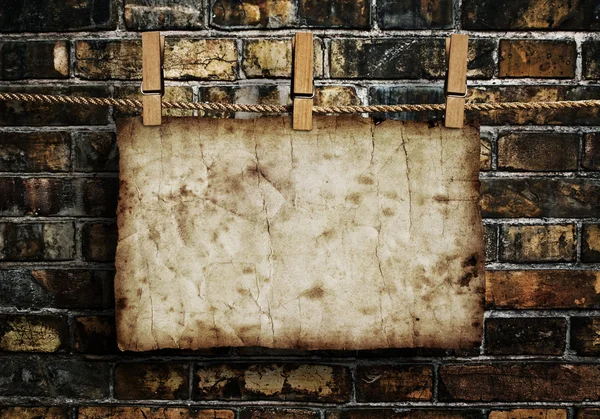 Old paper on brick wall — Stock Photo, Image